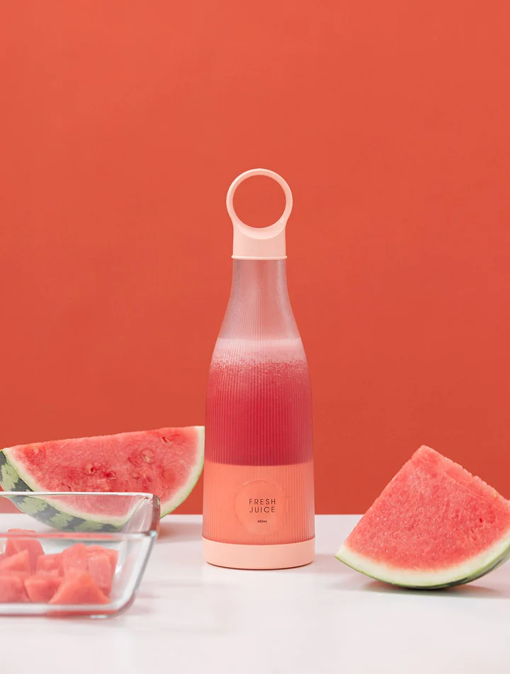 Une femme qui porte son fresh juice blender à la main dehors